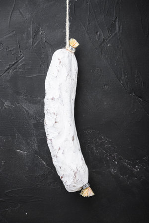 Salchichon, spanish salami sausage on black textured background.の写真素材