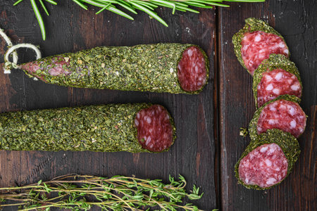 Traditional sausage salami fuet, cut to slices on dark wooden background.の写真素材