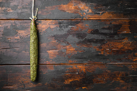 Dry salami fuet sausage in herbs on old wooden table, topview with space for text.の写真素材