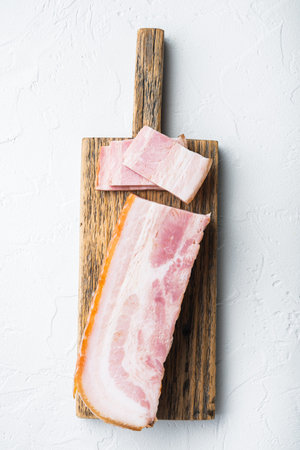 Smoked bacon, whole slab on white background, top view.の写真素材