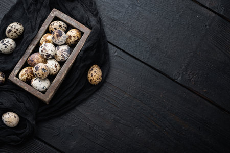 Fresh quails eggs, flat lay, on black wooden background with space for textの写真素材