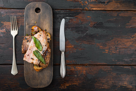 Liver bacon and onions on bread cooked meal served on board, over wooden background, top view with copy space.の写真素材