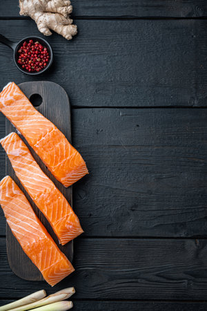 Fishcakes ingredient with salmon herbs and spices, on black wooden table, top view with space for textの写真素材