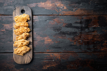 Fried chicken wings parts on old dark wooden table, flat lay, with copy space.の写真素材