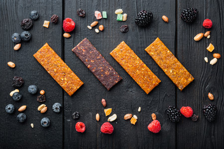 Dried fruits energy bars, flat lay, on black wooden table