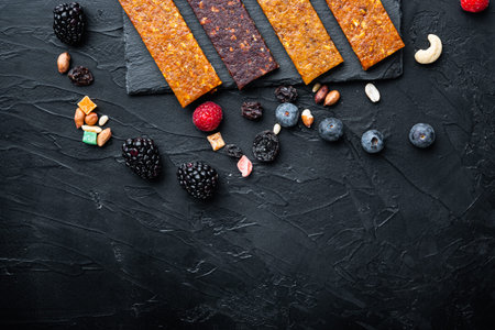 Dried fruits energy bars, flat lay with space for text, on black background