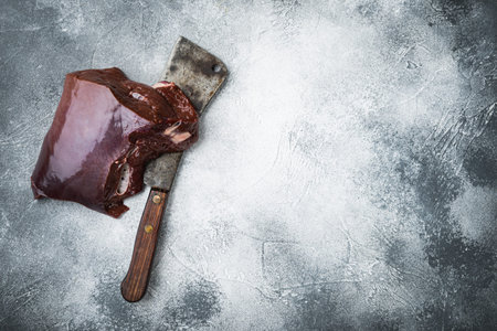Raw liver on gray background, flat lay with copy space.