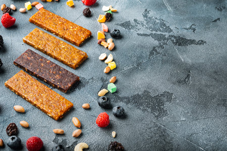 Healthy fitness energy bars with dried fruits and nuts with copy space, on gray background