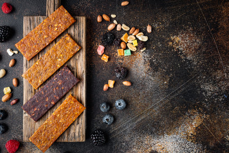 Dried fruits energy bars, top view with copy space, on old dark table
