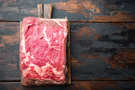 Strip loin steak, raw marbled beef meat, on old wooden table, top view, with copy space for textの写真素材