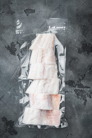 Haddock fish skinless in vacuum package, on gray background, top view