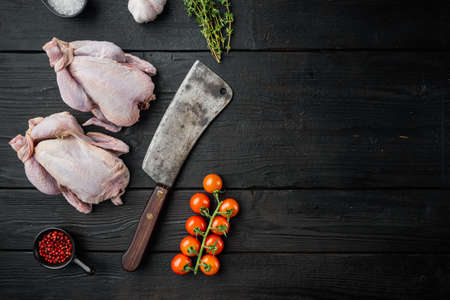 Fresh raw whole chicken carcass with herbs spices, on black wooden table, top view with copy space for textの写真素材