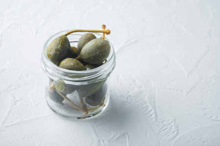 Organic pickled, canned capers, on white background with copy space for text
