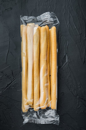 Breadsticks, with olive oil, on black background, flat layの写真素材