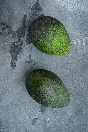 Ripe pair of green avocado set, on gray background, top view or flat lay