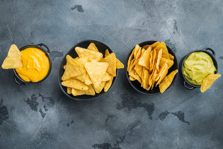 Nachos corn chips with traditional dip sauce set, on gray background, top view or flat lay with copy...