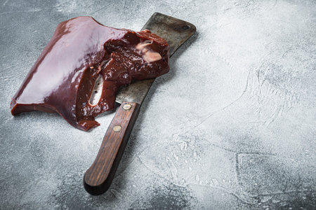Raw liver on gray background with copy space.