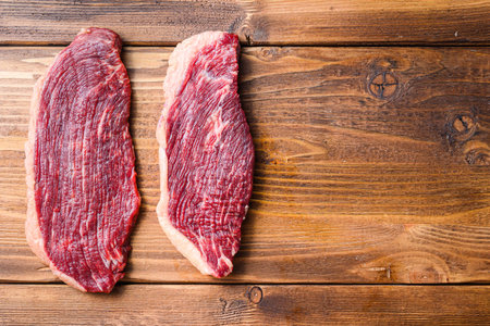 Picanha organic beef steaks over wooden table. Top view with space for textの写真素材