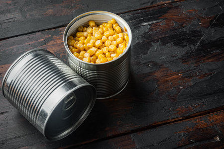 Canned corn in can, on old dark wooden table background with copy space for textの写真素材