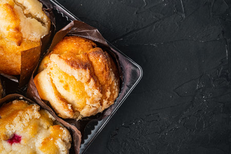 Muffins in plastic container, on black background, top view flat lay with copy space for textの写真素材