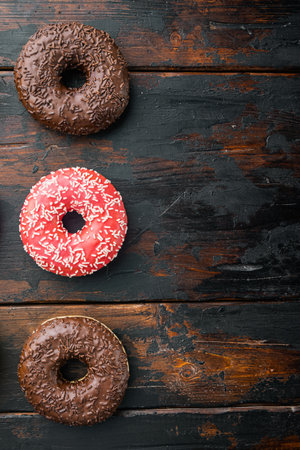 Glazed donuts set, on old dark wooden table background, top view flat lay with copy space for textの写真素材
