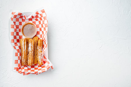 Churros with sugar powder, in the box in paper tray, on white background, top view flat lay with space for text, copyspaceの写真素材
