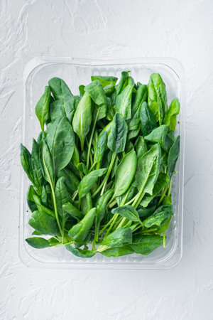 Fresh spinach set, on white background, in plastic pack, top view flat lay