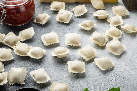 Tasty raw ravioli with flour and basil set, on gray background, with copyspace and space for textの写真素材