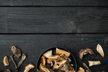 Mix of chopped wild dried mushrooms set, on black wooden table background, top view flat lay, with space for text copyspaceの写真素材