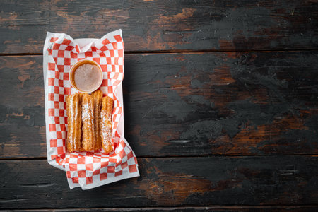 Spanish porras. Spanish food like spanish churros with chocolate, and caramel in paper tray, on old dark wooden table background, top view flat lay with space for text, copyspaceの写真素材