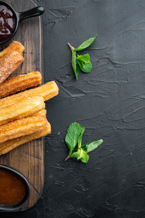 Churros with caramel, Traditional Spanish cusine, on black background, top view flat lay with space for text, copyspaceの写真素材
