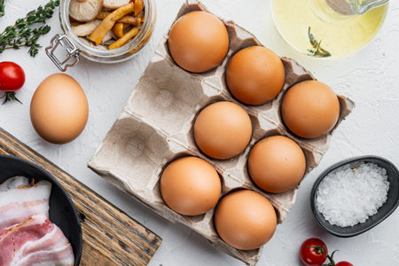Fresh eggs on paper egg box set, on white background, top view flat lay
