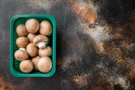 Brown champignons mushroom, on old dark rustic background, in plastic pack, top view flat lay , with space for text copyspaceの写真素材