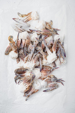 Fresh raw flower crab or blue crab frozen parts set, on white background, top view flat lay