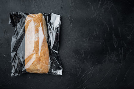 Ciabatta panini bread in a plastic bag, on black background, top view flat lay, with copyspace and space for textの写真素材