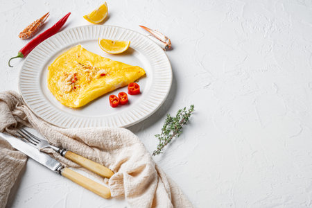 Thai Asian omelette, fresh red chilli, brown and white crabmeat, lemon, Cheddar cheese and eggs, on plate, on white background, with copyspace and space for textの写真素材