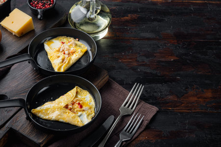 Chilli crab silky omlette, on frying iron pan, on dark wooden background, with copyspace and space...