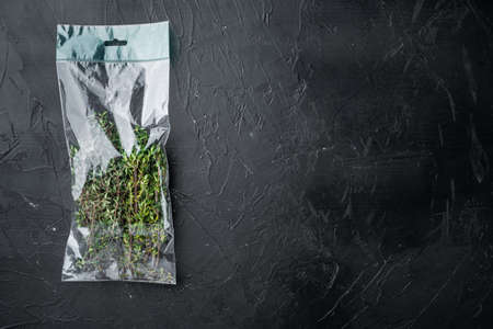 Thyme in plastic bag set, on black background, top view flat lay, with copyspace and space for textの写真素材
