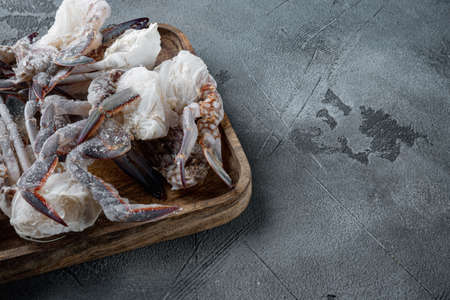 Frozen raw blue swimming crab meat set, on wooden tray, on gray background, with copyspace and space for textの写真素材