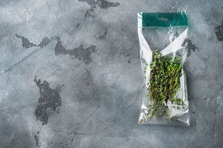 Thyme in plastic bag set, on gray background, top view flat lay, with copyspace and space for text