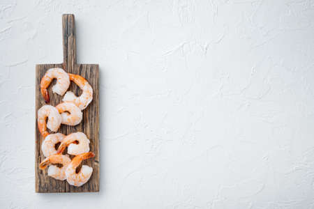 Whole fresh peeled cooked prawns, shrimps set, on wooden cutting board, on white background, top view flat lay, with copyspace and space for textの写真素材
