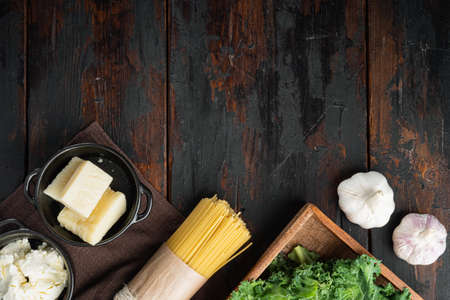 Italian food. Vegetables, olive oil, herbs and pasta set, on old dark wooden table background, top view flat lay, with copyspace and space for textの写真素材