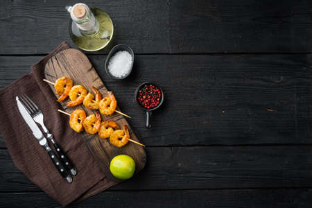 Shrimps on skewers with Mango chutney curry sauce set, on black wooden table background, top view flat lay, with copyspace and space for textの写真素材