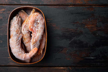 Langoustines argentine frozen set, in wooden box, on old dark wooden table background, top view flat lay, with copyspace and space for textの写真素材