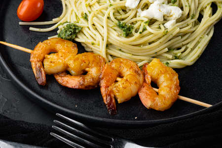 Seafood spaghetti pesto ready to eat set, on plate, on black backgroundの写真素材