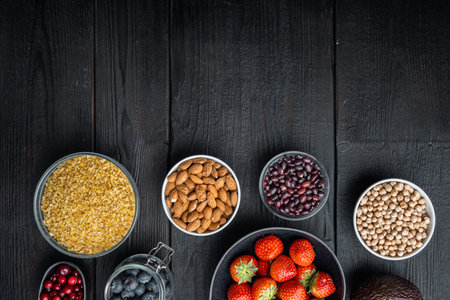 Superfoods dieting clean concept, top view with space for text, on black wooden background.