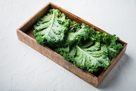 Fresh green kale leaf. King of nutrition set, in wooden box, on white background