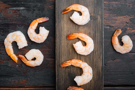 Peeled shrimps set, on wooden cutting board, on old dark wooden table background, top view flat layの写真素材