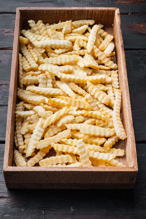Frozen fries set, in wooden box, on old dark wooden table background