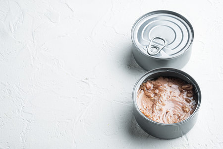 Tuna in a can, whole and chopped set, in tin can, on white background, with copyspace and space for...